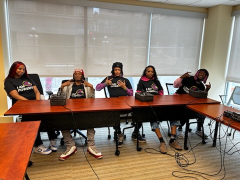 photo of five face to face youth leaders seated behind tables with microphones on the tables in st paul minnesota to record their visions for their futures with tek burch at safezone